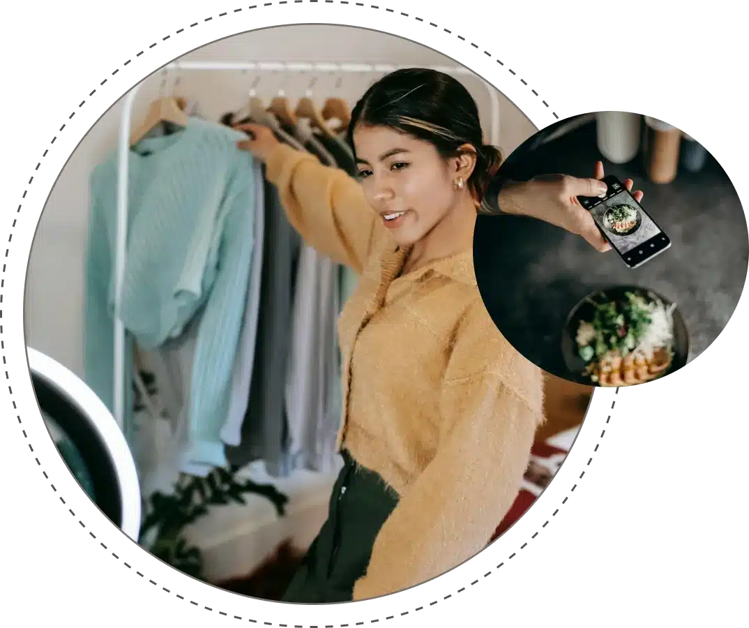 a woman holding a phone and holding a clothing rack
